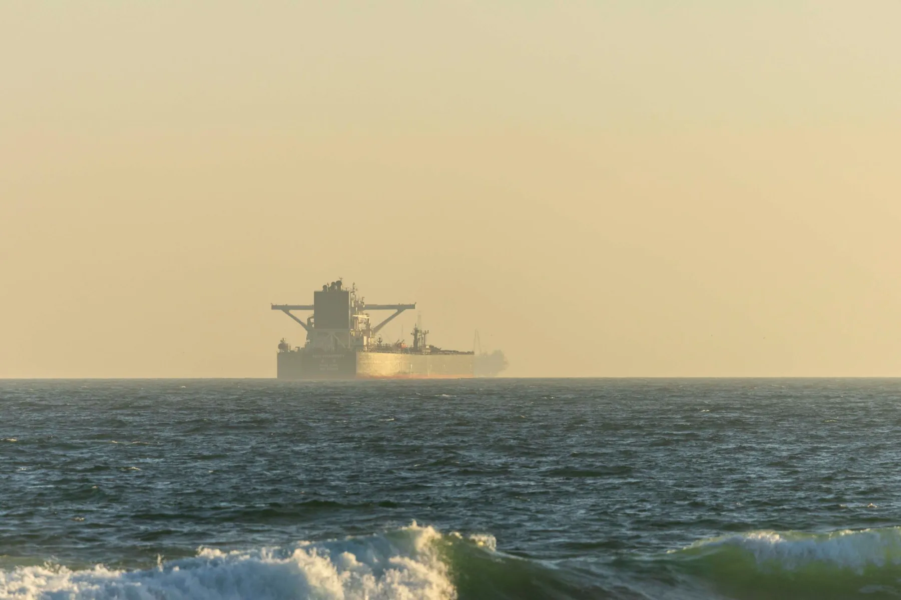 The Gulf horizon at dusk, a lone vessel on open water